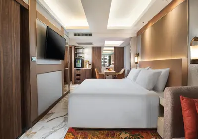 a hotel room with a large bed and a television at SAMALA Hotel Bangkok in Bangkok