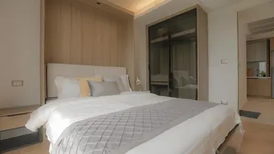 a bedroom with a large white bed with pillows at Funstay Bangkok Circle Condo in Bangkok