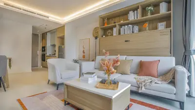 a living room with a white couch and a table at Funstay Bangkok Circle Condo in Bangkok