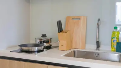 a kitchen counter with a sink and a wooden knife block at Funstay Bangkok Circle Condo in Bangkok