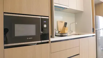 a kitchen with a microwave and a sink at Funstay Bangkok Circle Condo in Bangkok