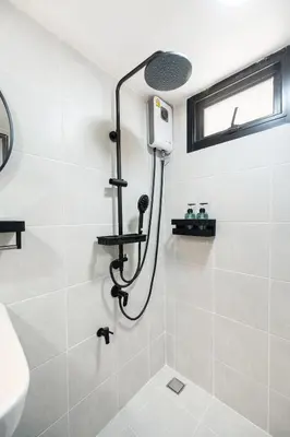a shower with a shower head in a bathroom at The Mellow at Ekkamai in Bangkok