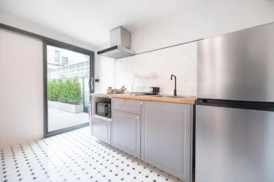 a kitchen with stainless steel appliances and a large window at The Mellow at Ekkamai in Bangkok