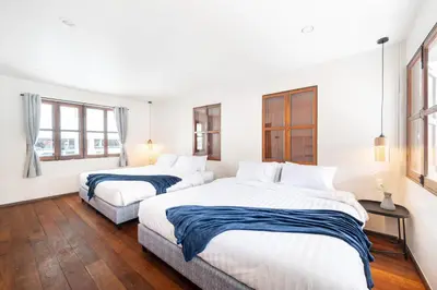 two beds in a room with white walls and windows at The Mellow at Ekkamai in Bangkok