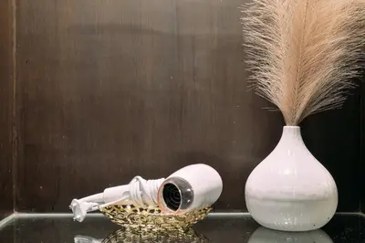 a white vase sitting next to a white vase with a plant at Tori crown hotel in Bangkok