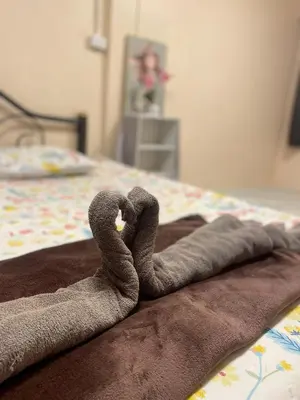 a rolled up towel on top of a bed at Rhythm of life guesthouse 56 in Bangkok