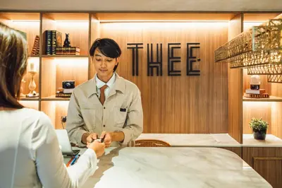 a man shaking hands with a woman at a table at THEE Bangkok by TH District in Bangkok