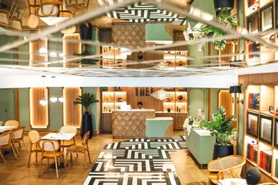 a lobby of a restaurant with tables and chairs at THEE Bangkok by TH District in Bangkok