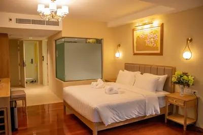 a bedroom with a bed with towels on it at Siri Grand Bangkok Hotel in Bangkok