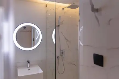 a bathroom with a shower with a mirror and a sink at CORRIDOR 2407 in Bangkok