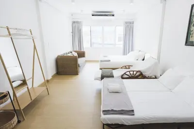 a white room with two beds and a couch at Nitichai Place, Private Sukhumvit Townhome 8PAX in Bangkok
