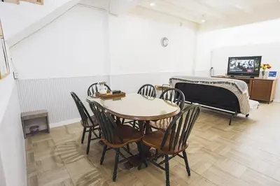 a room with a table and chairs and a bed at Nitichai Place, Private Sukhumvit Townhome 8PAX in Bangkok