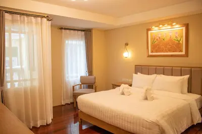 a bedroom with a bed with two stuffed animals on it at Siri Ratchadamnoen Bangkok Hotel in Bangkok