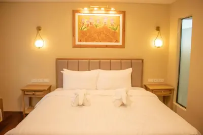 a bedroom with a bed with two stuffed animals on it at Siri Ratchadamnoen Bangkok Hotel in Bangkok