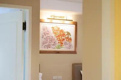 a picture of flowers on a wall in a bathroom at Siri Ratchadamnoen Bangkok Hotel in Bangkok