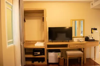 a room with a desk with a television on it at Siri Ratchadamnoen Bangkok Hotel in Bangkok