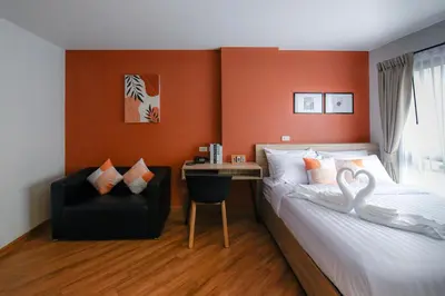 a bedroom with a bed and a chair and a desk at You Hotel in Ban Zong Katiam