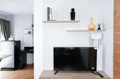 a living room with a television and a living room with a wall at You Hotel in Ban Zong Katiam