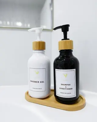 two bottles of soap on a wooden shelf at You Hotel in Ban Zong Katiam