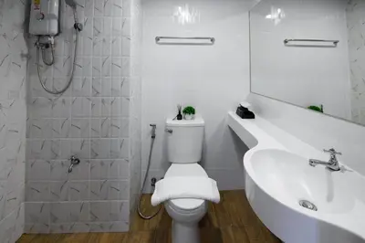 a white bathroom with a toilet and a sink at You Hotel in Ban Zong Katiam