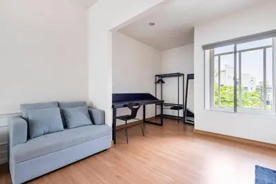 a living room with a couch and a desk at 55th AREA in Nonthaburi