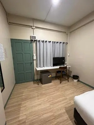 a room with a bed and a desk and a television at Bangwa House - MRT Bangwa Station in Bangkok