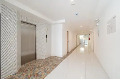 a hallway of a building with a door and a tile floor at The Urban Oasis in Bangkok