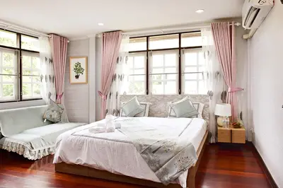 a bedroom with a bed and two chairs and windows at Suttisan \u5730\u94c1\u53e3\u4e8c\u5c42\u72ec\u680b\u82b1\u56ed\u522b\u5885 \u4e94\u5367\u5ba4\u4e09\u536b in Bangkok