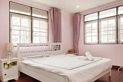 a bedroom with a large bed with pink walls and windows at Suttisan \u5730\u94c1\u53e3\u4e8c\u5c42\u72ec\u680b\u82b1\u56ed\u522b\u5885 \u4e94\u5367\u5ba4\u4e09\u536b in Bangkok