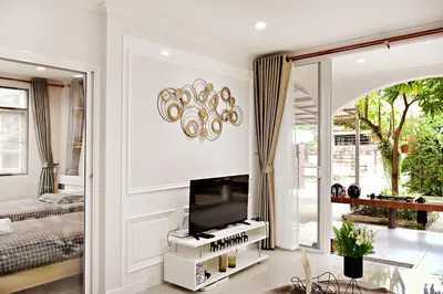 a living room with a tv and a mirror at Suttisan \u5730\u94c1\u53e3\u4e8c\u5c42\u72ec\u680b\u82b1\u56ed\u522b\u5885 \u4e94\u5367\u5ba4\u4e09\u536b in Bangkok