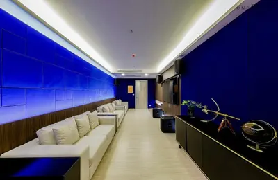 a waiting room with white couches and a blue wall at Central world Rama9/One9five公寓/Jadd夜市 in Bangkok