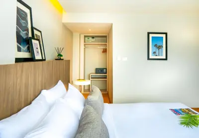 a bedroom with a bed with white pillows at Jazzotel Bangkok in Bangkok