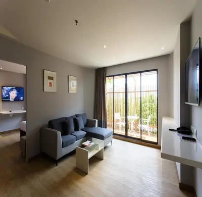 a living room with a blue couch and a balcony at Jazzotel Bangkok in Bangkok