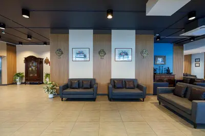 a waiting room with couches and chairs in a lobby at Prom Hotel in Bangkok
