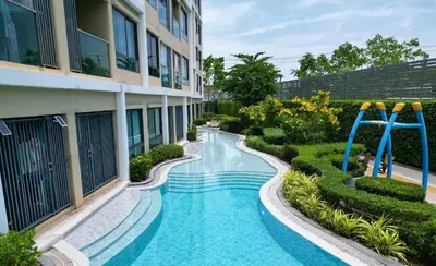 a swimming pool in front of a building at Resort Style Room Suksawat 64 Bangkok ND in Ban Tha Hin