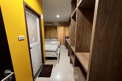 a small room with a bed and a yellow wall at Anh Anh Homestay in Bangkok