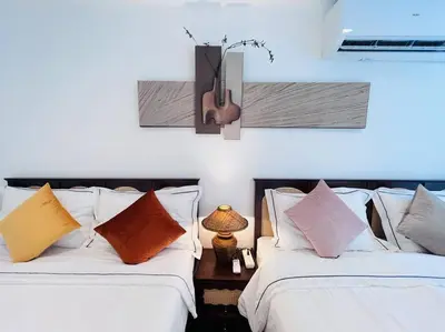 two beds with pillows and a guitar on the wall at \u5e02\u4e2d\u5fc3Ruam\u7cbe\u54c1\u522b\u5885 in Bang Kapi
