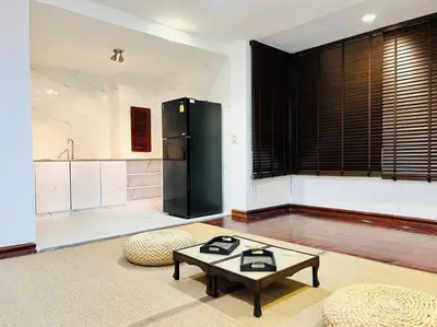 a living room with a table and a black refrigerator at \u5e02\u4e2d\u5fc3Ruam\u7cbe\u54c1\u522b\u5885 in Bang Kapi