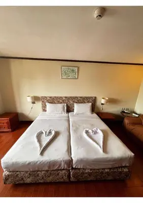 a bedroom with a bed with two heart shaped pillows at Affordable Serviced Apartments in Nana Omni Tower - Prime Sukhumvit location in Bangkok