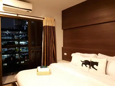 a bedroom with a bed and a large window at Bed By City Hotel in Bangkok