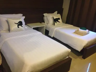a hotel room with two beds with cats on the pillows at Bed By City Hotel in Bangkok