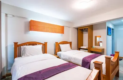 a bedroom with two beds and a mirror at XX GO INN Khaosan Road Bangkok - โกอินน์ ถนนข้าวสาร กรุงเทพฯ in Bangkok