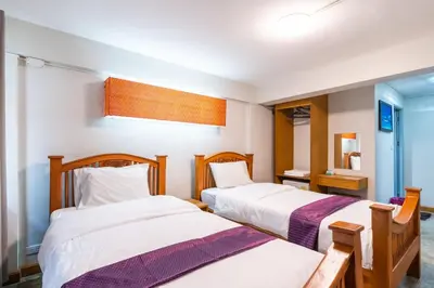 a bedroom with two beds and a mirror at XX GO INN Khaosan Road Bangkok - โกอินน์ ถนนข้าวสาร กรุงเทพฯ in Bangkok