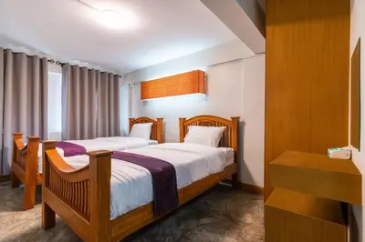 a hotel room with two beds and a desk at XX GO INN Khaosan Road Bangkok - โกอินน์ ถนนข้าวสาร กรุงเทพฯ in Bangkok