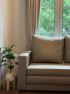 a couch in front of a window with a plant at Entire 3BR Townhome in Sukhumvit, shared Pool, near BTS&MRT Asok in Bangkok