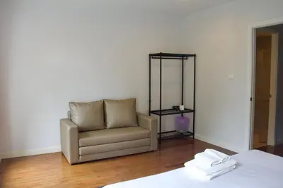 a living room with a chair and a mirror at Entire 3BR Townhome in Sukhumvit, shared Pool, near BTS&MRT Asok in Bangkok