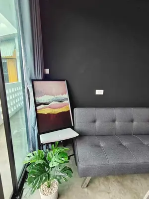 a living room with a couch and a painting at Mr Black & Ms White -Self Check in accommodation in Pom Prap