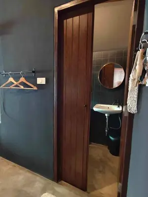a bathroom with a wooden door and a sink at Mr Black & Ms White -Self Check in accommodation in Pom Prap