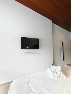 a bedroom with a bed with a tv on the wall at Mr Black & Ms White -Self Check in accommodation in Pom Prap