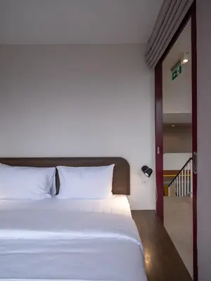 a bedroom with a white bed and a sliding glass door at Bedtime storeys near ICON SIAM in Bangkok
